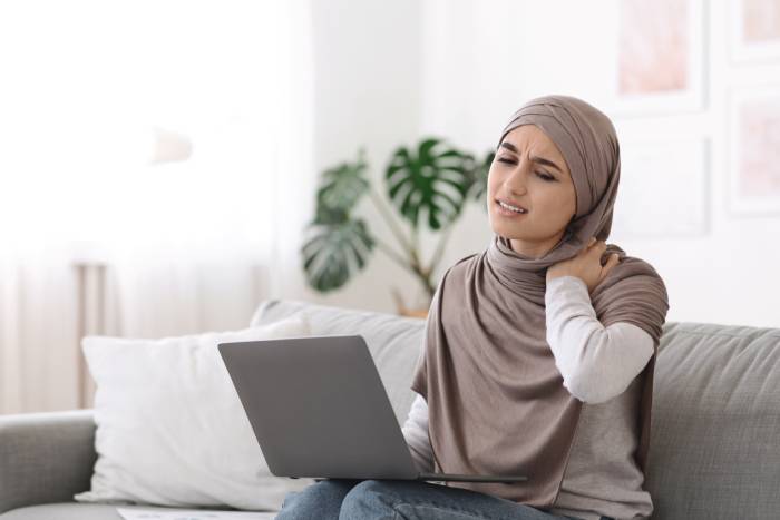 femme avec des douleurs dans la nuque, travail sur le canapé